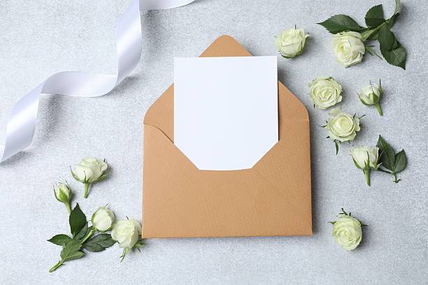 istock Beautiful white roses with paper envelope on light background 2253629732