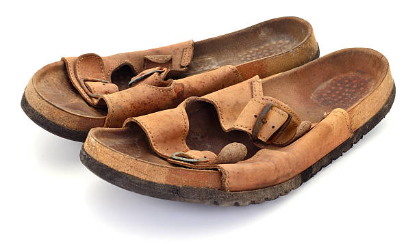 istock Title Pair of old worn leather sandals isolated on white 2253631209