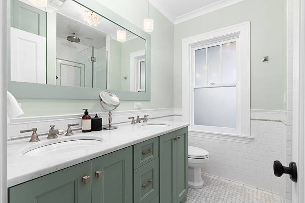 istock A green bathroom with a marble countertop and basketweave tile flooring. 2253632364