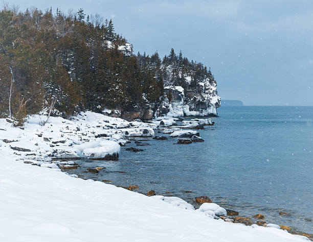 istock Snowy winter shoreline and calm lake 2253632559