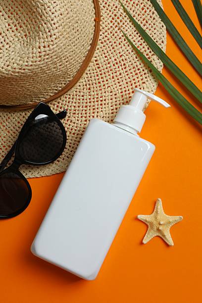 istock SPF skin care concept. White sunscreen bottle with hat and glasses on orange surface. 2253634607