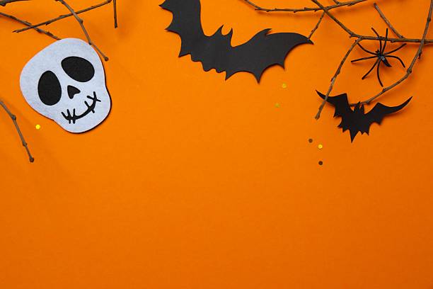 Vertical Halloween festive background design featuring bats, skull and decorative branches. Halloween concept