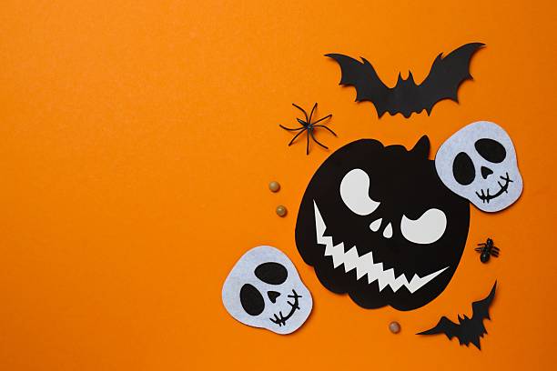 istock Halloween poscard with festive decorations on orange background . Top view, space for text 2253634653