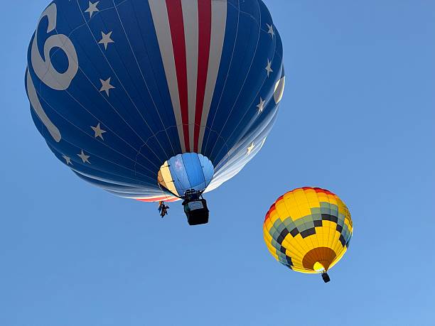 Hot air balloons in flight against sky in early morning hours in Colorado.   View from below