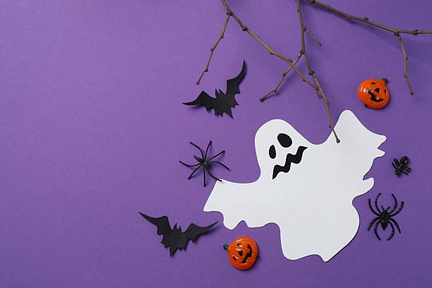 istock Halloween holiday decorations including pumpkins, spiders, ghost and bats on purple background 2253635621