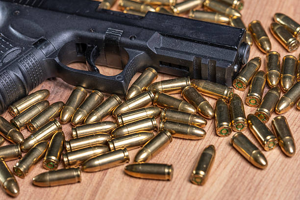 istock Close up of firearm trigger and brass cartridges 2253636046