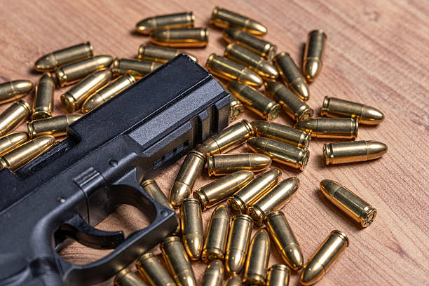 istock 9mm bullets scattered around black tactical handgun 2253636050