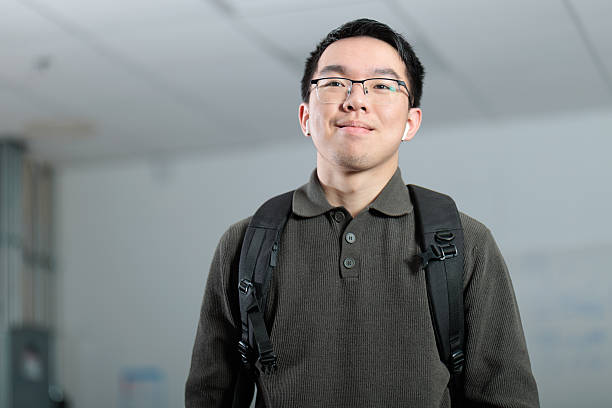 istock Student with backpack and wireless earbuds in school hallway 2253637351