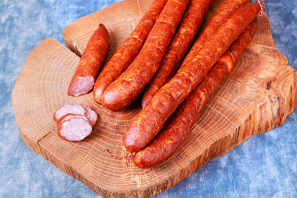 istock Sausages placed on wooden board ready for slicing in kitchen setting 2253639726