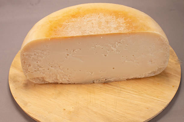 istock Smooth Textured Farmhouse Cheese With Golden Rind On Rustic Wooden Surface 2253640803