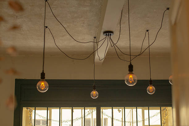 Urban cafe setting with glowing Edison bulbs at dusk, Ambient lighting from Edison pendants creates inviting atmosphere in city cafe during evening hours
