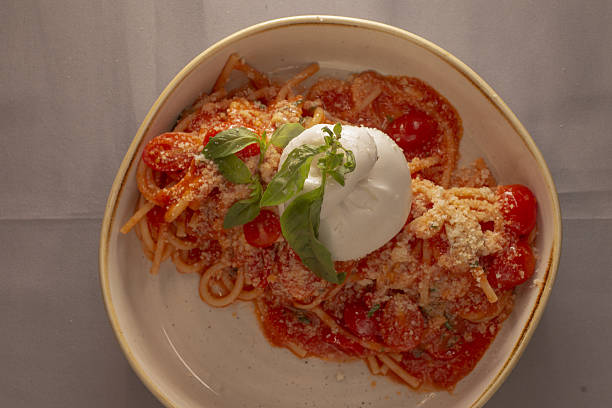 Elegant presentation featuring spaghetti with rich tomato and burrata cheese