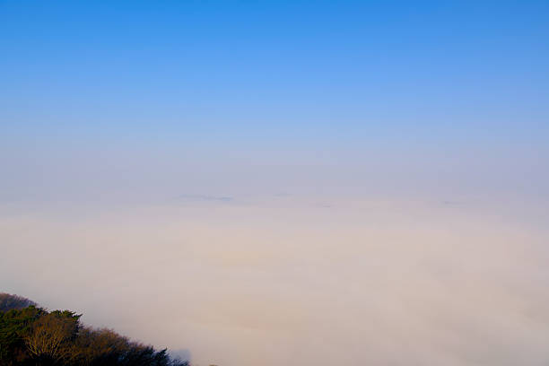 Scenery of a Misty morning in the mountains at Ba Lu Kho view piont, Mae Chaem, Chiang Mai in northern Thailand. Low clouds and fog rolling over green forest, Sea of fog