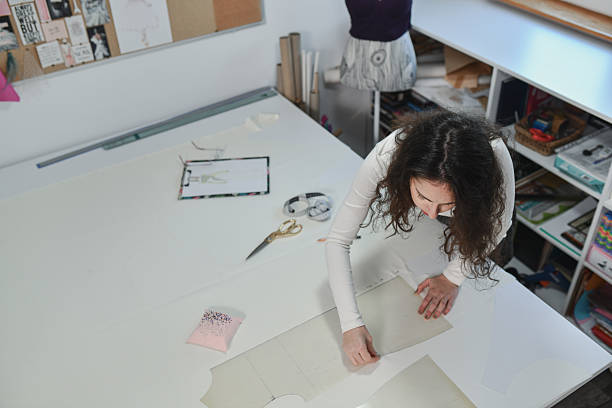 Seamstress working hands-on in a professional atelier, pinning fabric carefully for a custom dress.