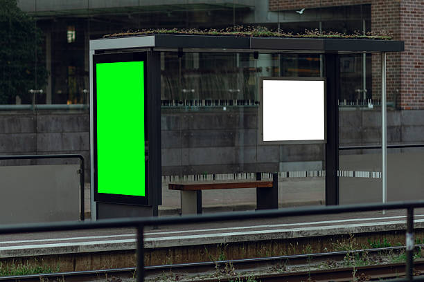 istock Modern glass bus stop shelter with vertical digital advertising billboard mockup 2253649052