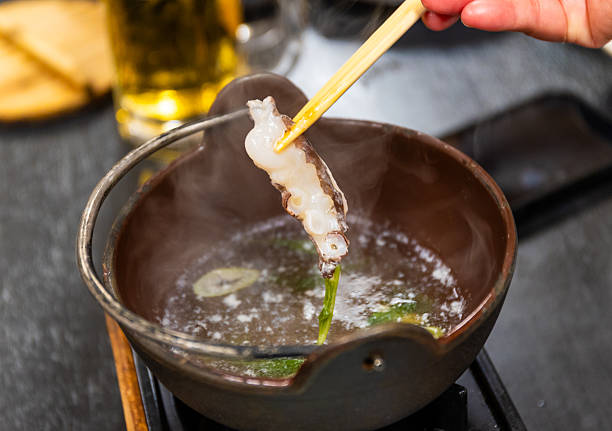 istock Picking up a slice of octopus from a hot pot bowl 2253649090