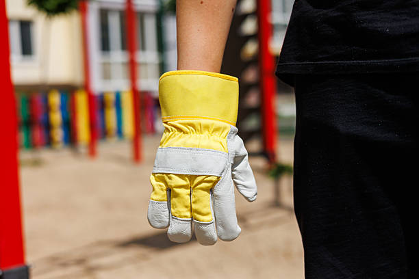 The protective work glove is currently hanging in a vibrant playground environment, highlighting the importance of safety gear alongside the themes of preparation and quality workmanship