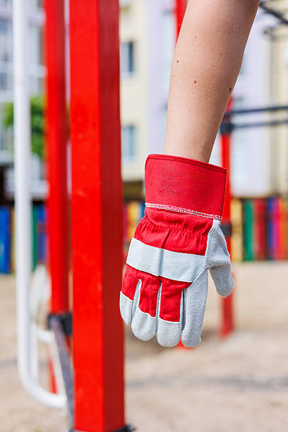 istock A closeup view of a singular work glove is hanging from a structure located in a playground, surrounded by a vibrant and colorful outdoor environment, showcasing a lively and inviting atmosphere 2253653407