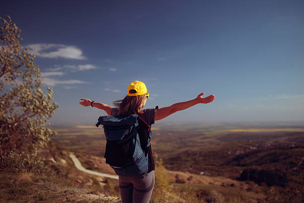 Joyful woman reaching the top admiring the view