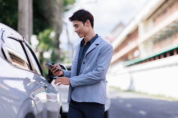 istock Young man using smartphone app to unlock car 2253655198