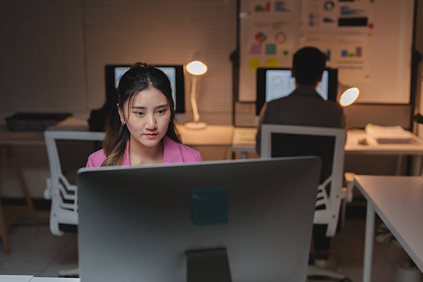 istock Woman working hard late night in office 2253659437