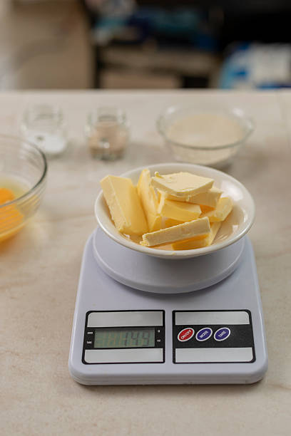 istock Butter pieces accurately weighing on a digital kitchen scale, preparing ingredients for baking recipes in a kitchen environment 2253660520