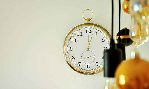istock Clock strikes twelve, three minutes after midnight. Round clock on a light wall, midnight time, New Year's Eve concept 2253663374