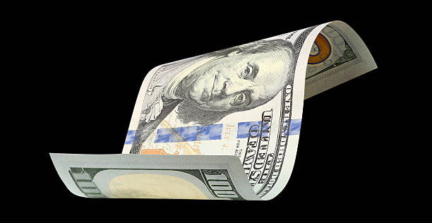 istock Curved hundred dollar banknote, isolated on black background 2253663912