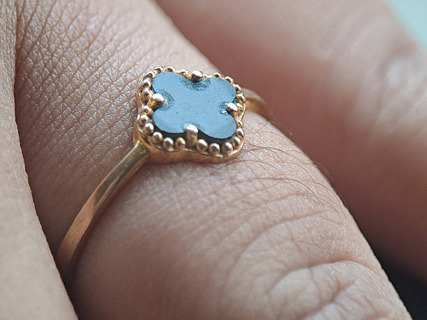istock gold ring with a blue gemstone set in a beaded bezel, worn on a finger indoors, captured in soft light, highlighting fine craftsmanship, elegance, and luxury jewelry design. 2253666233