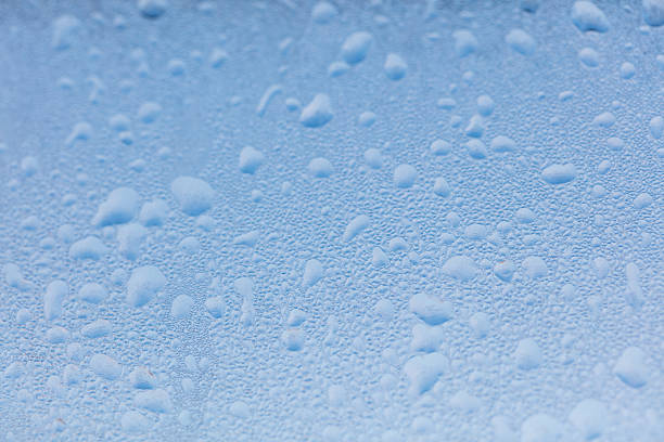 Frozen water drops on glass as an abstract background. Texture.
