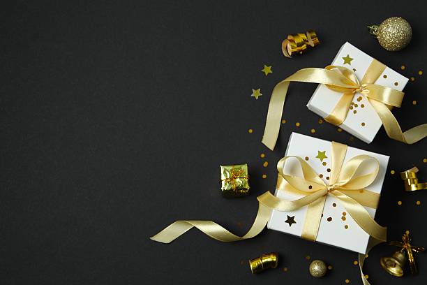 istock Beautiful gift boxes tied with bows and Christmas decorations on black background 2253667377