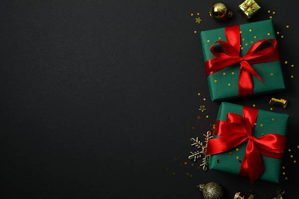 istock Beautiful gift boxes tied with bows and Christmas decorations on black background 2253667410