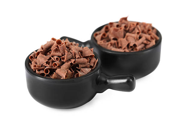 Delicious chocolate shavings in bowls isolated on white