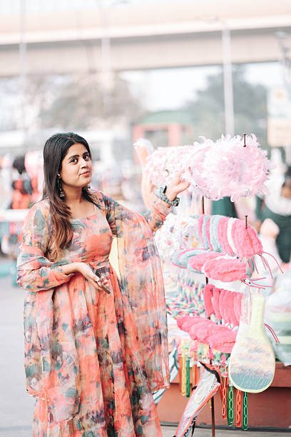 Female shopper exploring decorative fashion accessories at a street stall. Concept of casual shopping, personal style, and everyday urban lifestyle.