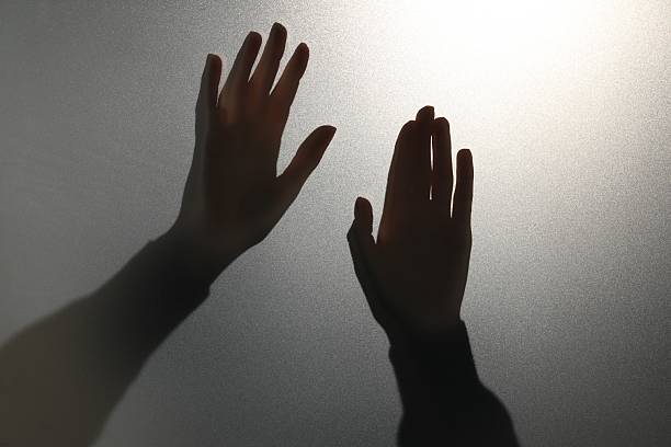 shadow of hands reaching for each other.