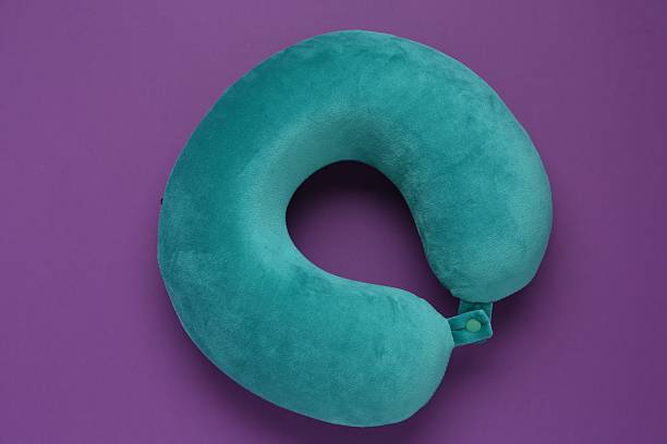 istock Turquoise travel pillow on purple background, top view 2253669108
