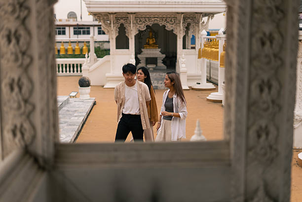 istock Young asian friends walking through a traditional thai temple grounds 2253671854