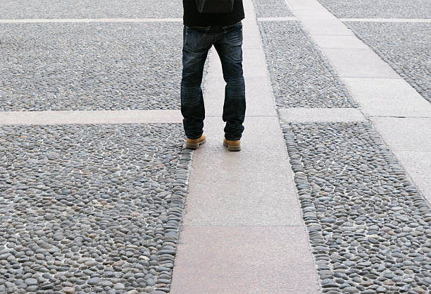 rear view of a unrecognizable  tourist standing in cobbled square