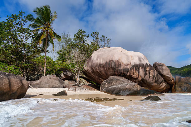 View on idyllic tropical beach with rocks and waves, clear blue sky, turquoise ocean, Seychelles islands