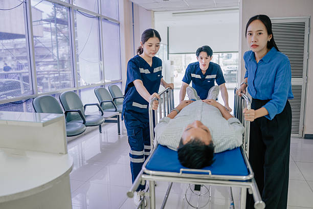 Asian healthcare workers rushes a male patient on a stretcher through a hospital corridor, moving with urgency and coordination toward critical treatment. Captured in a realistic handheld style, the scene reflects the intensity, teamwork, and responsibility involved in emergency medical care. Bangkok