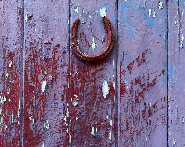An old iron horseshoe hanging on the wall. Close-up. Background. Texture.