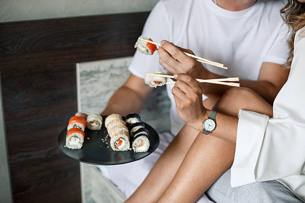 istock A man and a woman are thoroughly enjoying eating sushi using chopsticks 2253679814