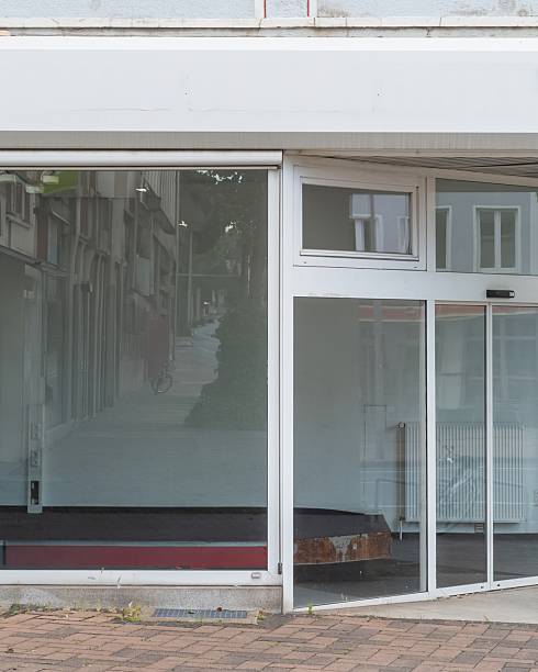 istock Empty storefront with large glass windows reflecting a quiet street in a urban area during the afternoon 2253682760
