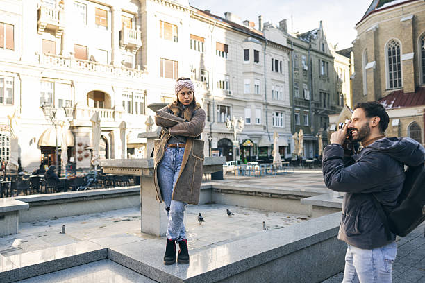 Smiling tourist couple taking photos in new city on beautiful day.