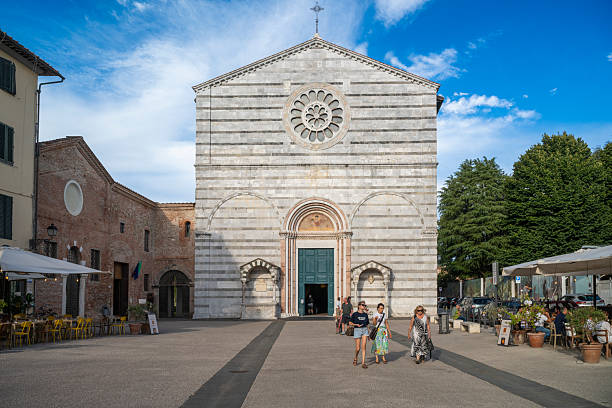 26 July 2025 Lucca, Italy. Front view of a historic striped stone church with rose window and arched entrance, framed by an open square and soft clouds, showcasing Chiesa di San Francesco in Lucca, Italy.