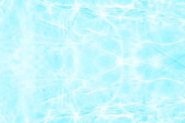 Small tiles in the background, clean light water waving and reflections in swimming pool full frame view suitable for  background purposes. Vigo city, Pontevedra province, Galicia, Spain.