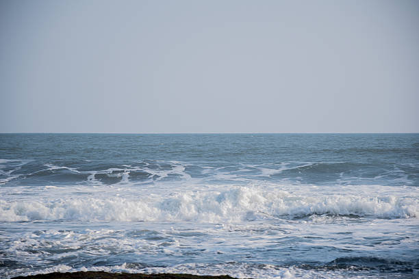 Gentle ocean waves rolling toward shore under a clear sky