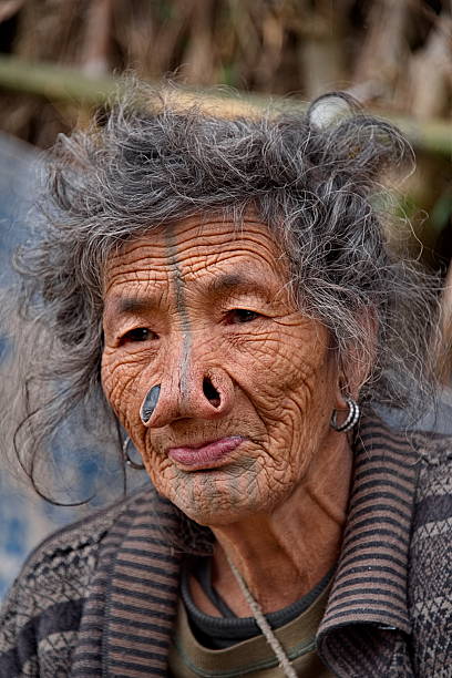 Sapa, Vietnam - March 26, 2024:An indigenous woman from a village around Sapa sells her handicrafts on the steps in the center of Sapa