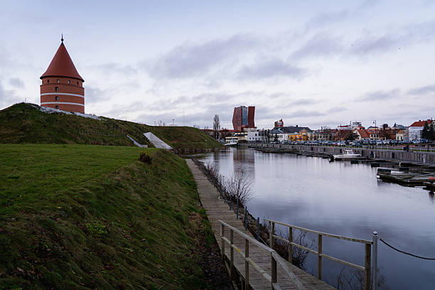 istock Serene waterfront cityscape with historic tower and modern buildings 2253701210
