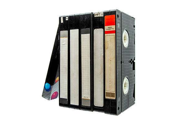 istock A stack of vintage black VHS video cassettes with blank white labels and one red label, isolated on a white background. 2253703639
